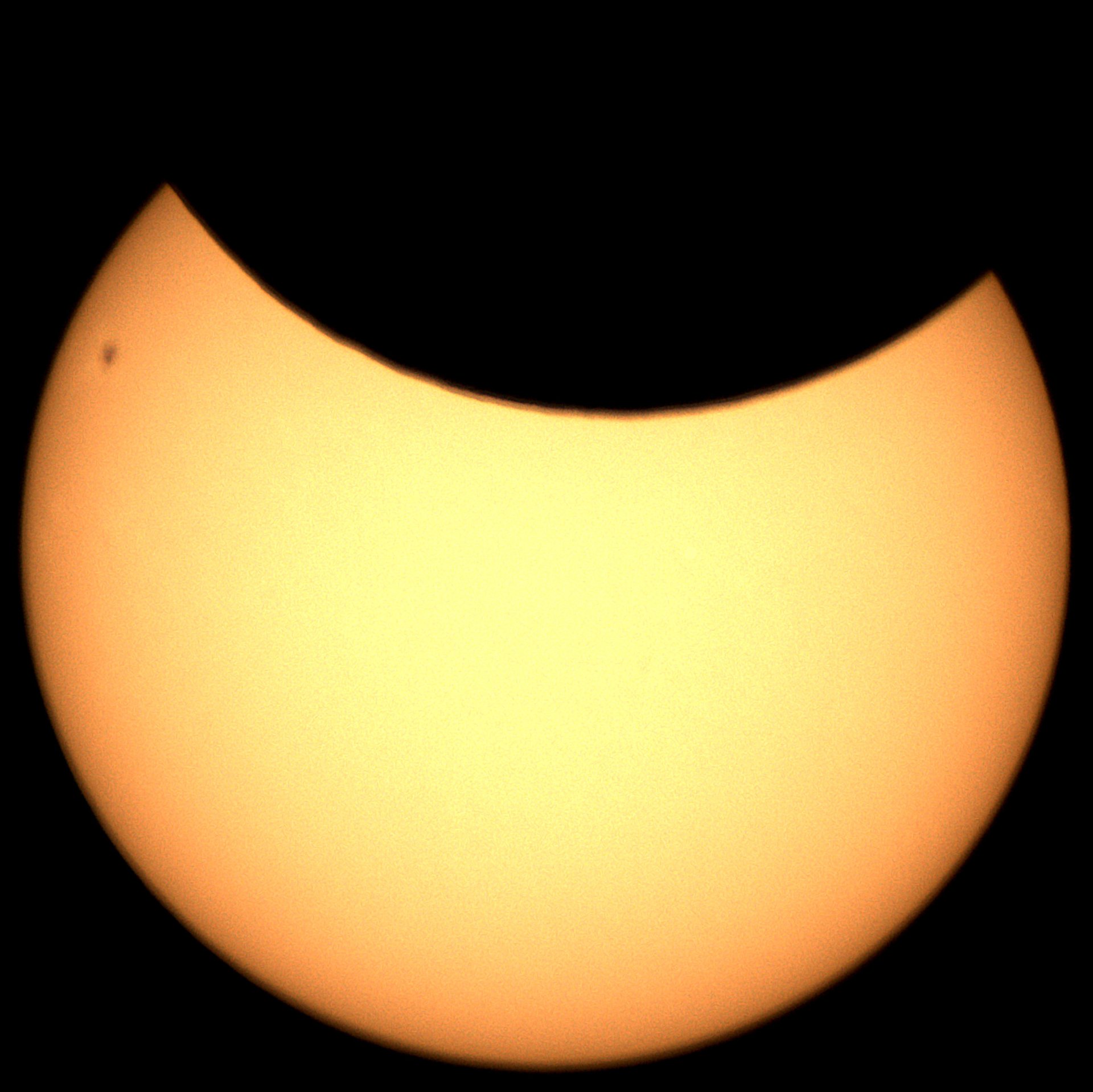 The partial solar elicpse of the 29th of March, 2025, as seen from England, captured using prime focus and a solar filter. Visible sunspot at the top-left. Originally white-ish and quite overexposed, what you see is my best attempt at saving it.